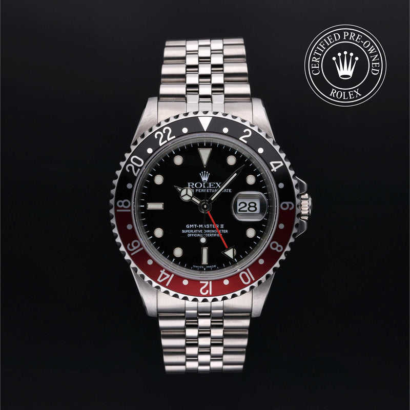 Rolex GMT-Master II with Jubilee bracelet, red and black bezel and black dial on a black background.
