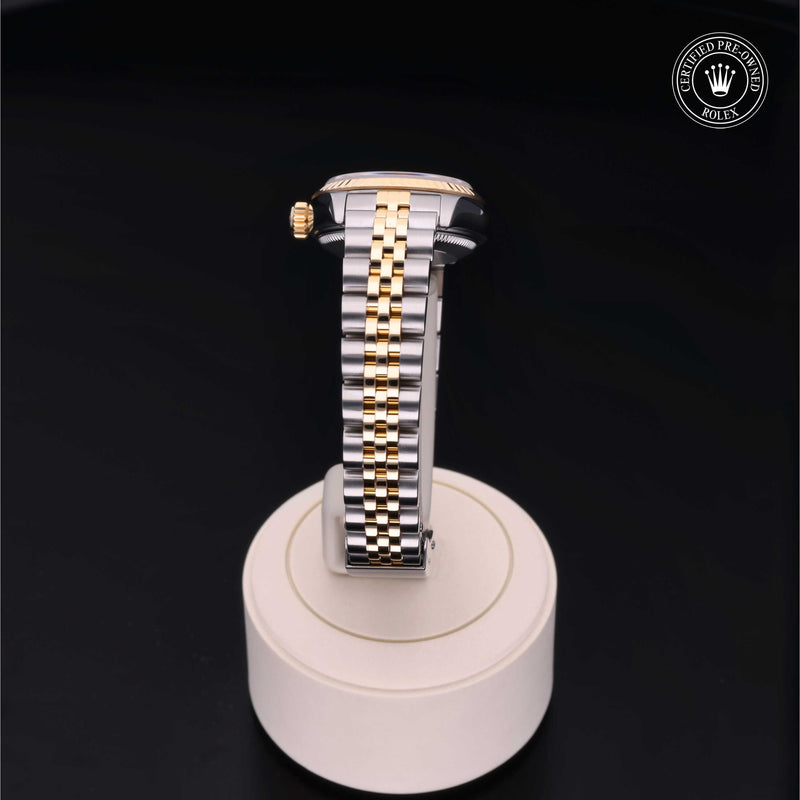 Rolex Lady-Datejust 26 with steel & yellow gold Jubilee bracelet and champagne dial on a cream presentation stand against a black background.Lady-Datejust 26