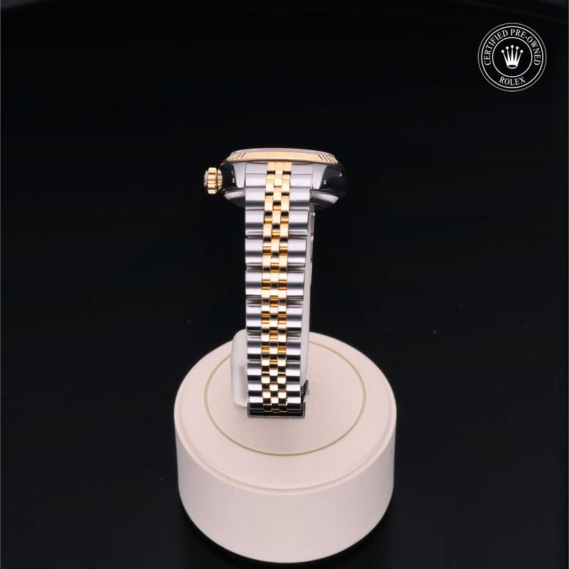 Rolex Lady-Datejust 26 with steel and yellow-gold Jubilee bracelet and champagne dial, on a cream presentation stand against a black background.Lady-Datejust 26
