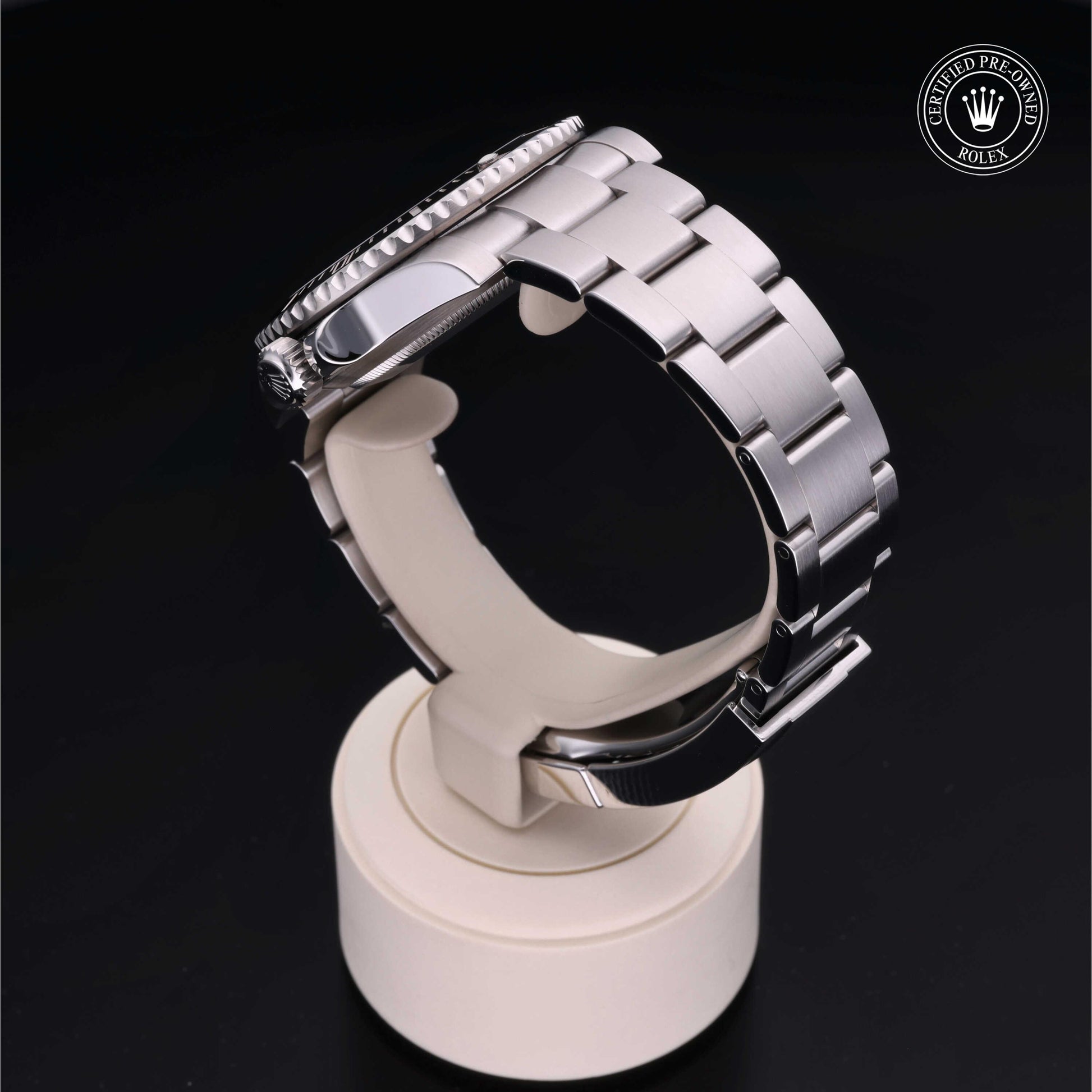 Rolex Submariner watch with steel Oyster bracelet and black dial on a white background.