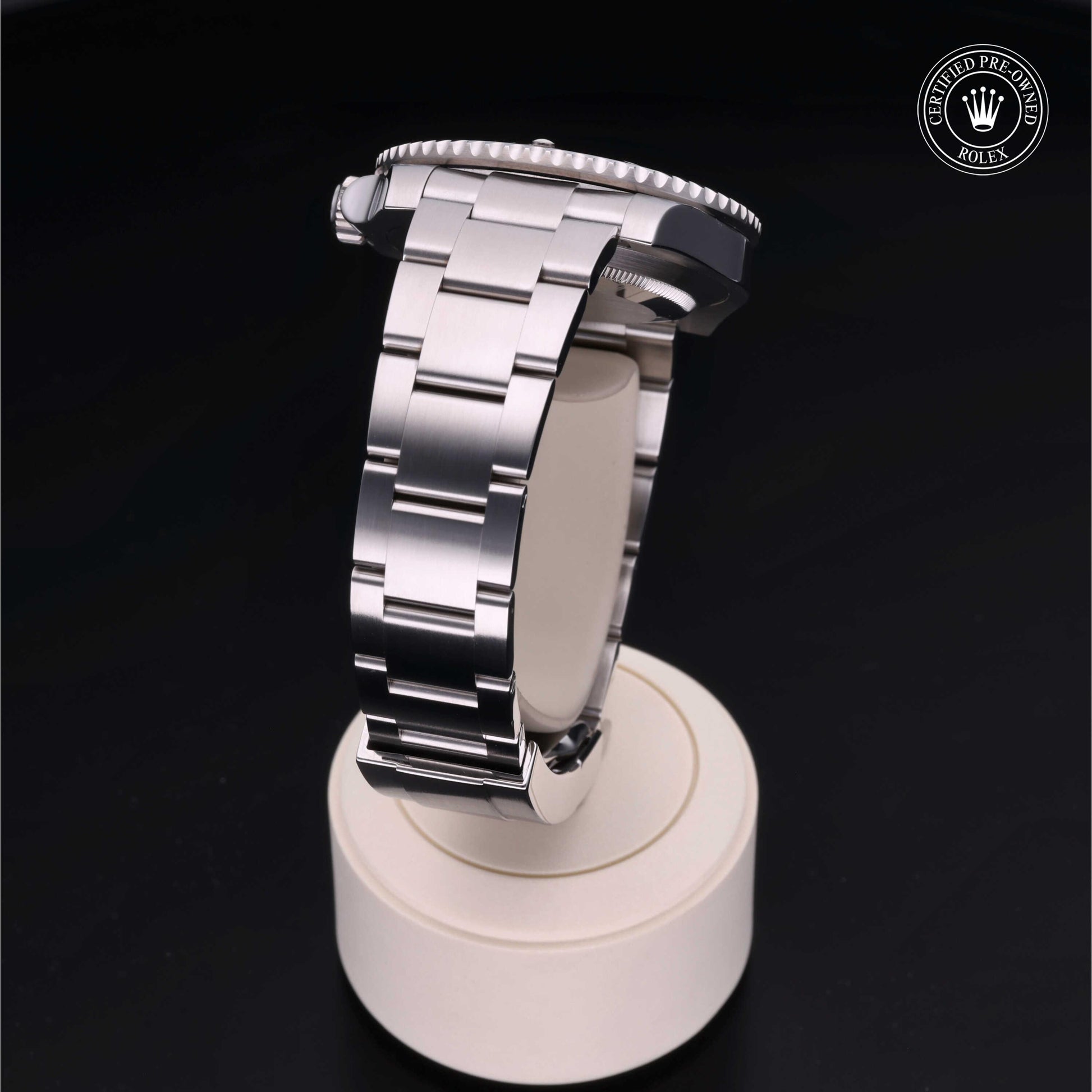 Rolex Submariner watch with steel Oyster bracelet and black dial on a white background.