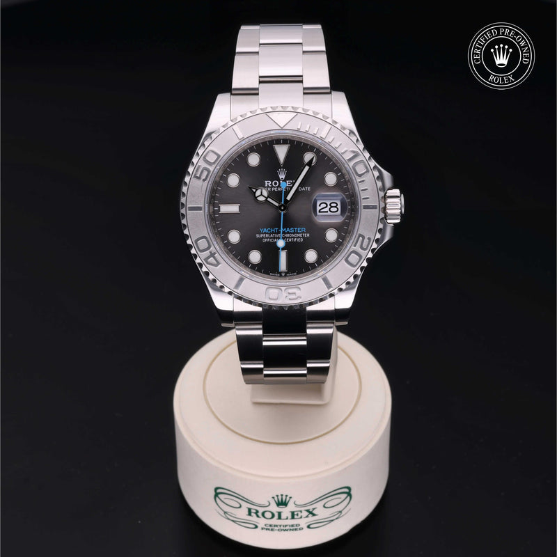 Rolex Yacht-Master watch with a steel Oyster bracelet and slate dial, presented on a cream stand with black background.Yacht-Master 40