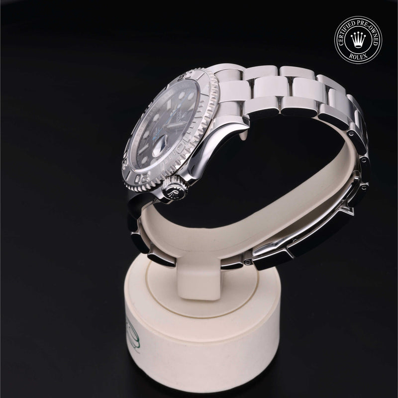 Rolex Yacht-Master watch with a steel Oyster bracelet and slate dial, presented on a cream stand with black background.Yacht-Master 40
