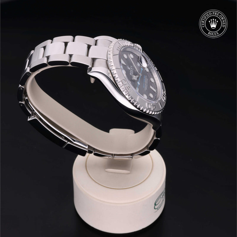 Rolex Yacht-Master watch with a steel Oyster bracelet and slate dial, presented on a cream stand with black background.Yacht-Master 40
