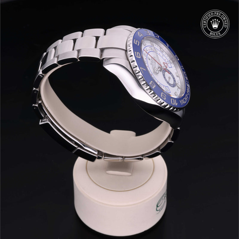 Rolex Yacht-Master II watch with a steel Oyster bracelet and white dial on a cream stand with a black background.Yacht-Master II