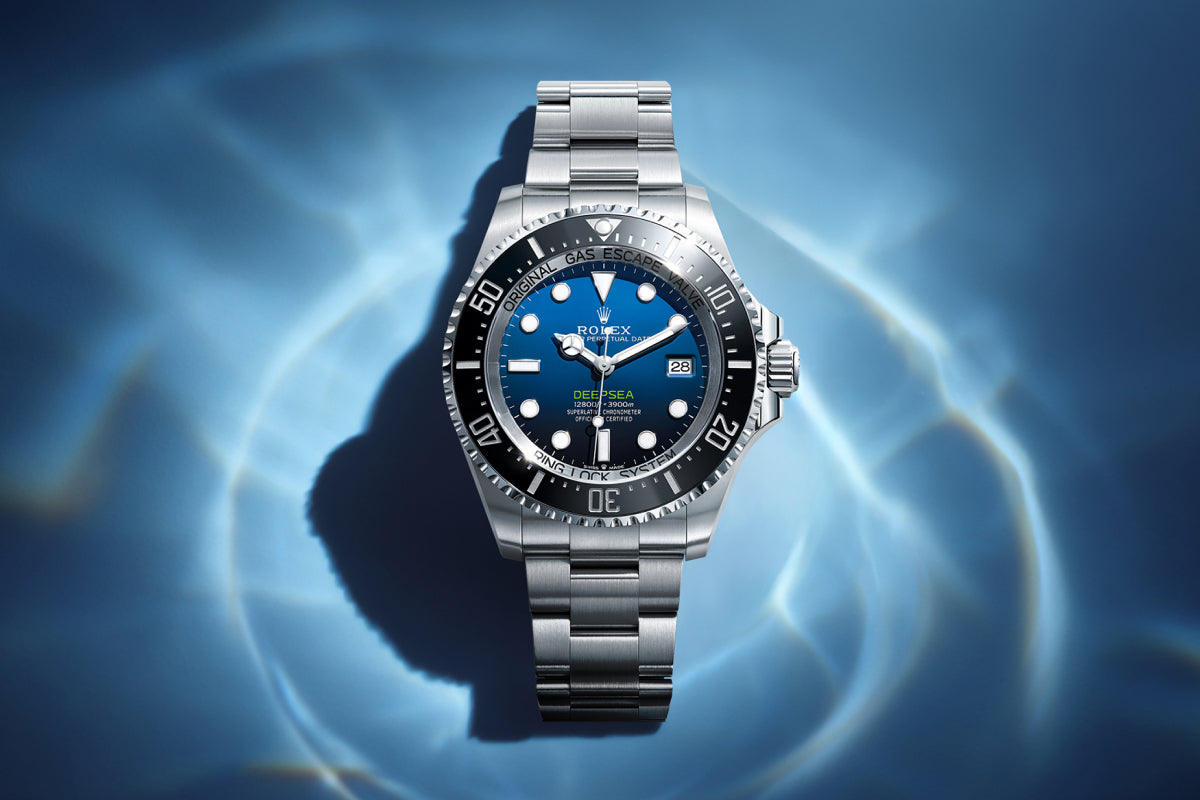 Rolex Deepsea watch with a steel bracelet and blue dial on a reflective background.
