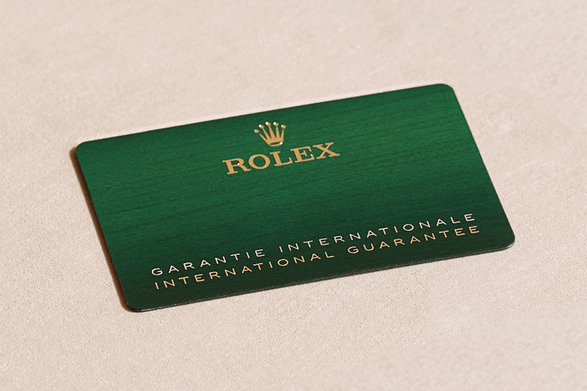 Rolex green warranty card on a beige background.