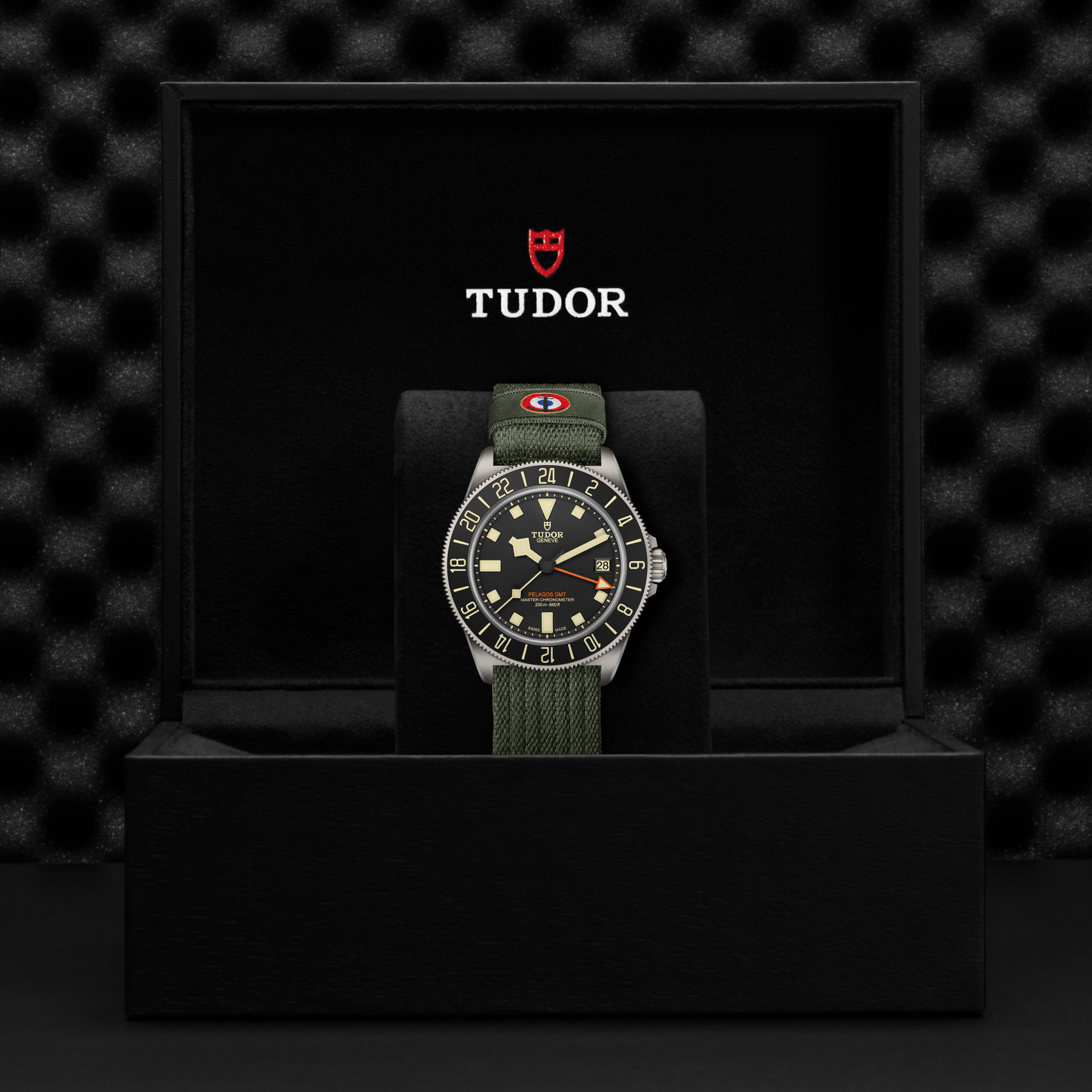 TUDOR Pelagos FXD GMT with 42mm titanium case, green fabric strap and black dial in black presentation box.