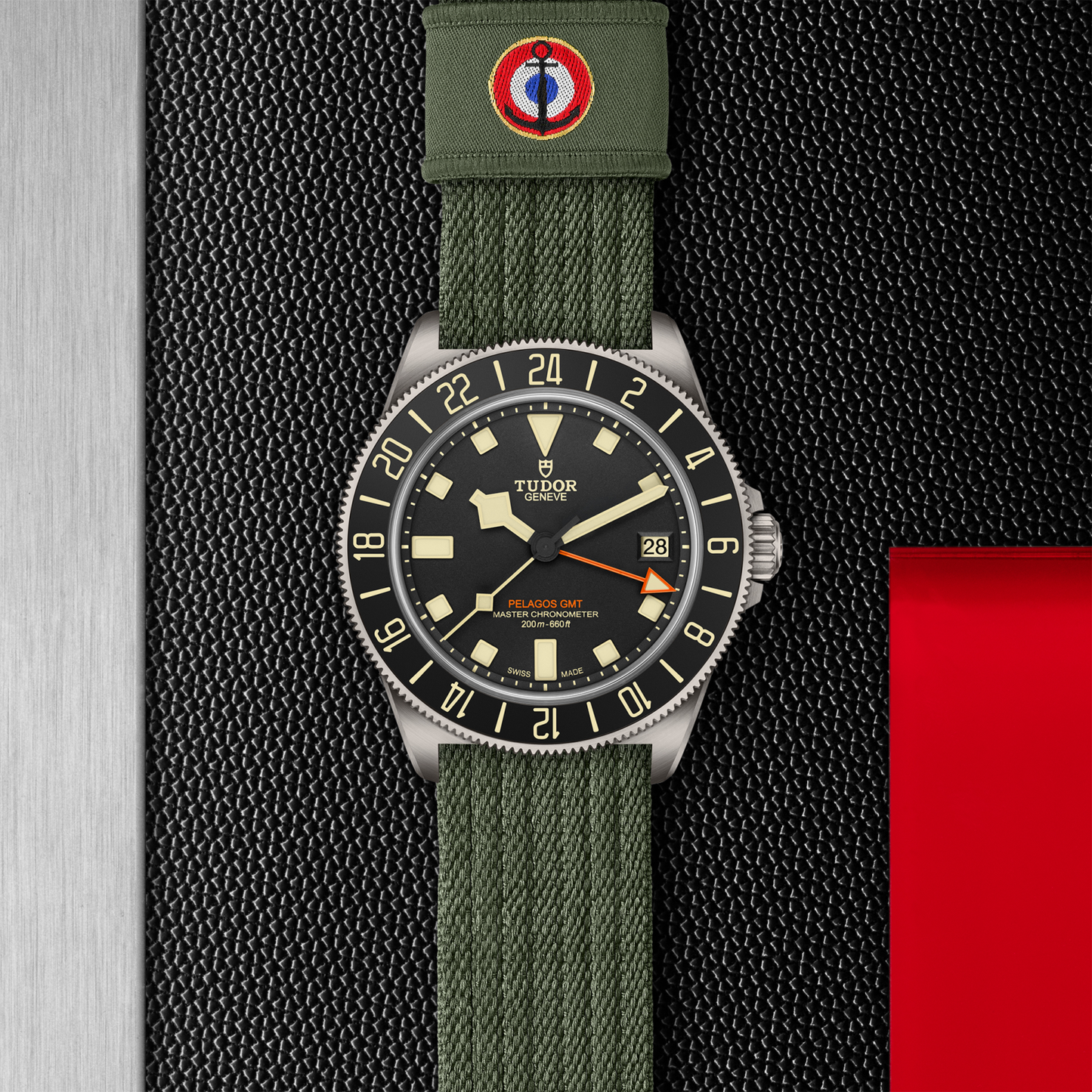 TUDOR Pelagos FXD GMT with 42mm titanium case, green fabric strap and black dial on a black background.